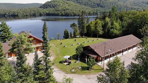 Le motel L'Ours Bleu et son terrain gazonné devant le lac Saguay